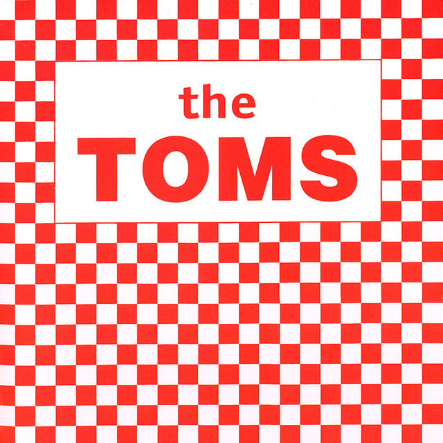 Album cover for The Toms by The Toms, featuring white dominant palette and typographic composition.