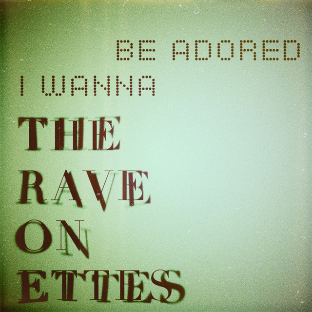 Album cover for I Wanna Be Adored by The Raveonettes, featuring green dominant palette and typographic composition.